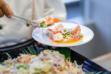 Traditional Thai Spicy Noodle Vermicelli With Seafood Shrimp Squid And Thai Herb On Cook Hand.
