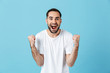 © Drobot Dean - Young screaming happy bearded man posing isolated over blue wall background make winner gesture.