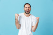 © Drobot Dean - Young screaming happy bearded man posing isolated over blue wall background make winner gesture.