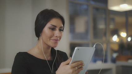 Aufkleber - A woman in the office talking with a tablet and smiles. UHD