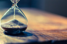 Sand Running Through The Bulbs Of An Hourglass Measuring The Passing Time In A Countdown To A Deadline With Copy Space.