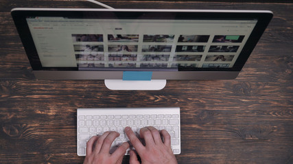 Aufkleber - Close up details male hands typing on keyboard. Person working at wooden desk with modern display.