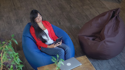 Aufkleber - Video call meeting. Asian woman talking with business partner or friends using internet and touch screen tablet. Businesswoman online meeting with client. Happy young girl sitting in modern loft