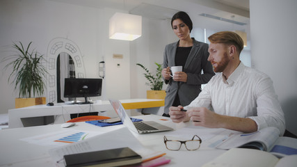 Poster - Two employees working in the office. Sit and use digital tablet and phone