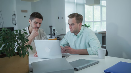 Poster - Colleagues at the workplace with computed looking on the screen. Young man professional happy and smiling. Handsome guys wearing in casual shirt.