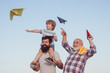 © Volodymyr - Happy fathers day. Happy grandfather father and grandson with toy paper airplane over blue sky and clouds background. Dream of flying. Generation of people and stages of growing up.