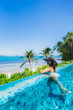 © siraphol - Portrait beautiful young asian woman relax in luxury outdoor swimming pool in hotel resort nearly beach sea ocean