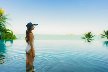 Portrait beautiful young asian woman relax in luxury outdoor swimming pool in hotel resort nearly beach sea ocean