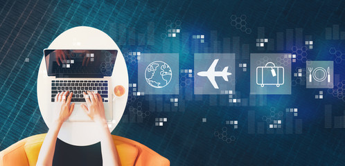 Wall Mural - Airplane travel theme with person using a laptop on a white table
