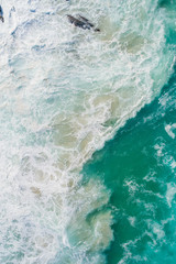 Wall Mural - Aerial view of a waves crashing and rolling in the ocean.