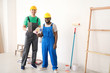 © Pixel-Shot - Male workers near light wall
