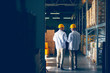 © Dusan Petkovic - Two smiling warehouse workers in white uniforms and yellow helmets on heads standing and talking about job. Backs turned.