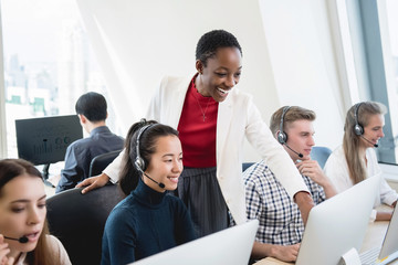 Wall Mural - African American female supervisor training work to multiethnic team in call center