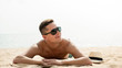 © Atstock Productions - Young handsome man lying at the beach on summer vacations