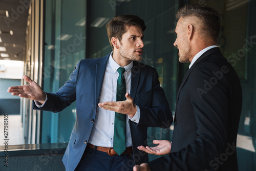 Fotografía Image of aggressive businessmen partners talking and discussing conflict while s