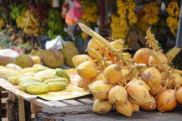 Wall Mural - Yellow coconuts are sold on the market in Asia. Sale of vegetarian fruits outdoors. Stock photo