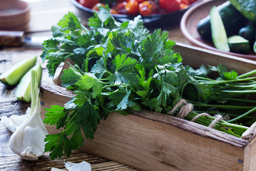 Wall Mural - Crate of freshly picked organic  parsley, roasted cherry  tomatoes, and fresh garlic on rustic  table