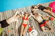 © rh2010 - Group of a happy friends in swimwear lying on the poolside, sunbathing near the swimming pool, view from above