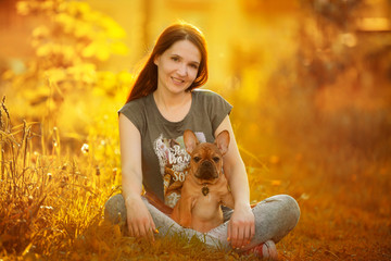 Wall Mural - young woman walking with a french bulldog puppy