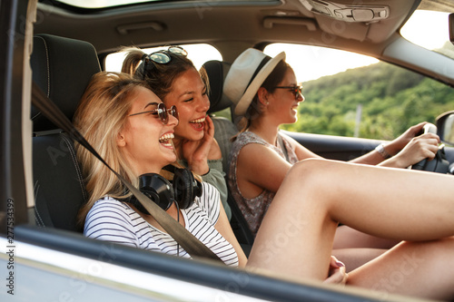 Three best female friends travel together.They drives a car and making fun.Summer vacation.