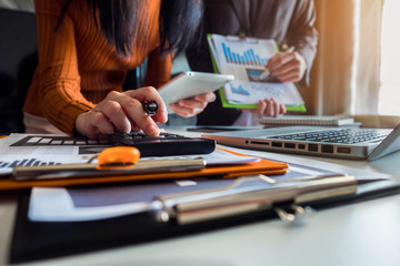 Co working team meeting concept: Business woman working and studying together with tablet document graph paper in office, discuss finance and marketing solution reporting file in working place.