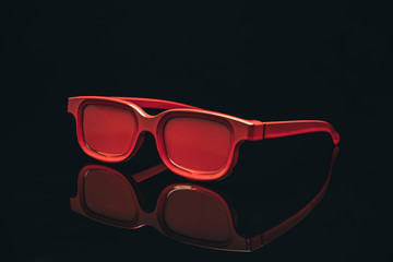 Fototapete - Red sunglasses on a black glass table background.