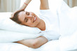© rogerphoto - Beautiful young and happy woman sleeping while lying in bed comfortably and blissfully smiling
