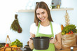 © rogerphoto - Young happy woman cooking soup in the kitchen. Healthy meal, lifestyle and culinary concept. Smiling student girl preparing vegetarian meal at home