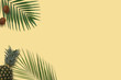 Top view yellow pineapple and kiwi flatlay. Summer minimal banner copyspace. Green palm leaves on the pastel background