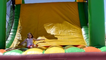 Poster - beautiful girl playing in an inflatable castle