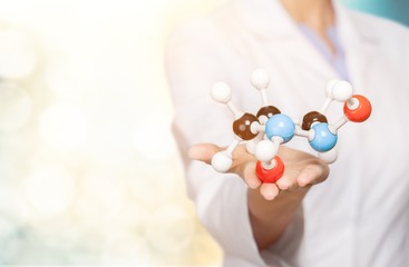 Wall Mural - Close up of Molecular structure model in hand on background