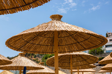 Umbrellas from the sun from the reeds on the beach against the sky