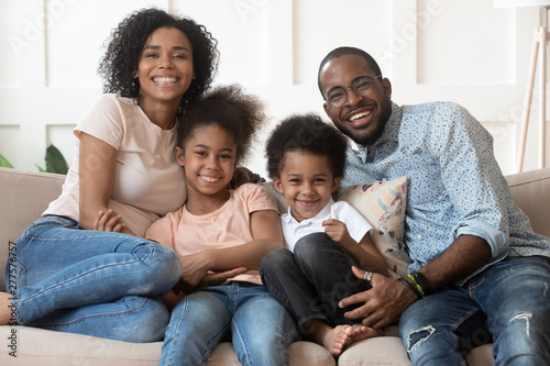 Fotomural Happy african family of four looking at camera at home