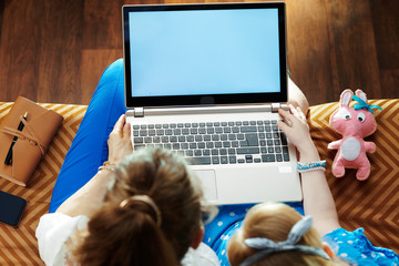 modern mother and daughter looking at blank screen on laptop