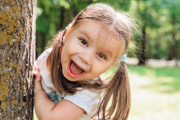 close-up portrait of an excited little girl laughing in park