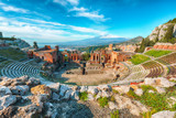 Fototapeta  - Ruins of ancient Greek theater in Taormina and Etna volcano in the background.