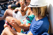 © Miljan Živković - Two women using mobile phone on the ship in summer day looking at the pictures sending and reading messages on vacation holiday