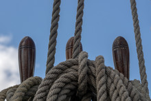 Halyards And Ropes Coiled And Secured By Belaying Pins On A Historical Sailing Ship