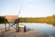 A chair with fishing items on a wooden dock on a lake in Ontario Canada in summer 