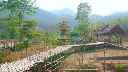 Poster - PAI, THAILAND - MAY 5, 2019: Walk through the curved Boon Ko Ku So bamboo bridge with shady pavilions, Buddhist shrine and dry agricultural lands around it, on May 5 in Pai