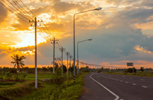 Landscape In The Fields And Background, Orange Sky, Twilight And Electric Poles On The Road
