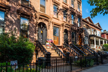 Scenic View Of A Classic Brooklyn Brownstone Block With A Long Facade And Ornate Stoop Balustrades On A Summer Day In Clinton Hills, Brooklyn