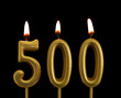 Golden birthday candles isolated on black background, number 500
