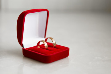 classic wedding rings in red boxing are on the white table. two golden wedding rings isolated on whi