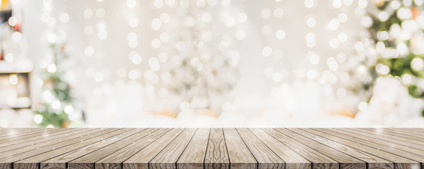 empty woooden table top with abstract warm living room decor with christmas tree string light blur b