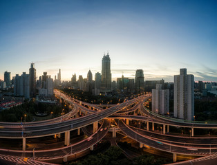 Wall Mural - aerial view of buildings and highway interchange at dawn in Shanghai city