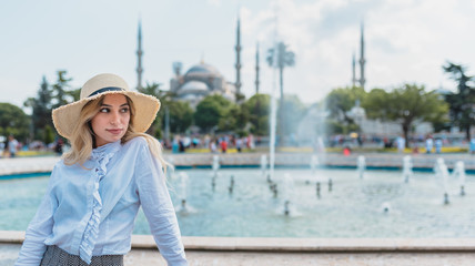 Wall Mural - Beautiful girl poses in front of Mosque