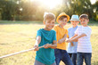 © Pixel-Shot - Group of children pulling rope at summer camp