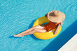© Pixel-Shot - Beautiful young woman relaxing on inflatable ring in swimming pool
