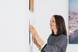 © contrastwerkstatt - frau hängt bilder an die wand